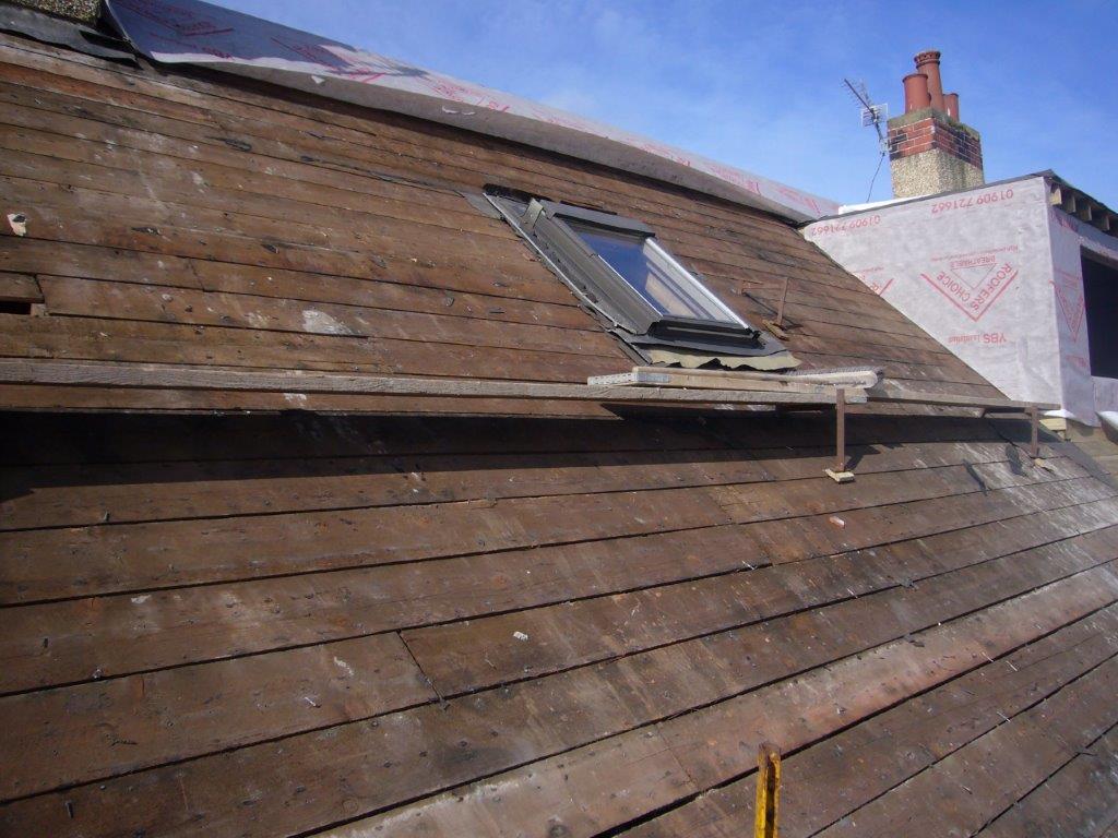 Roof inspector checking tiles and taking notes